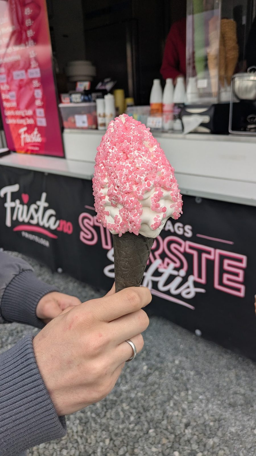 Ekte Frista-softis med rosa strø i svart kjeks foran softisvogna
